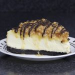 A delicious cheesecake with chocolate drizzled on top